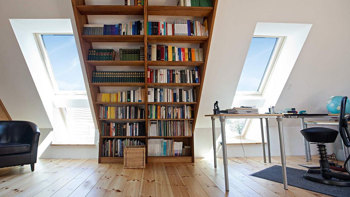 Bücherregal in einer Dachgeschosswohnung mit Dachfenster in Tandem-Einbauweise